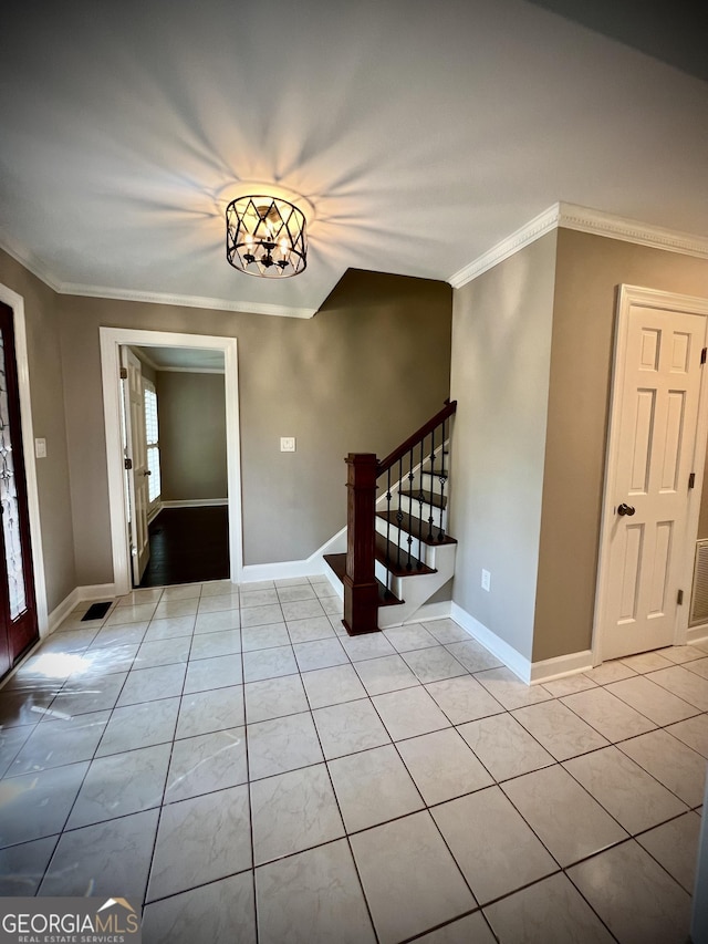 tiled foyer entrance with crown molding