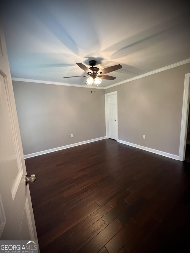 spare room featuring ceiling fan, dark hardwood / wood-style floors, and crown molding