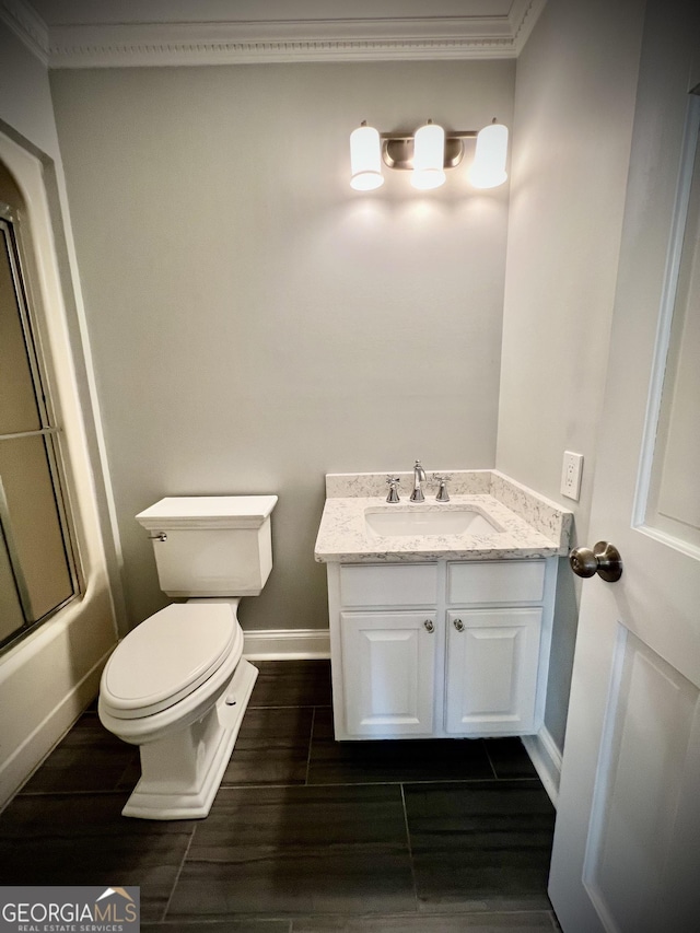 full bathroom with vanity, toilet, bath / shower combo with glass door, and ornamental molding