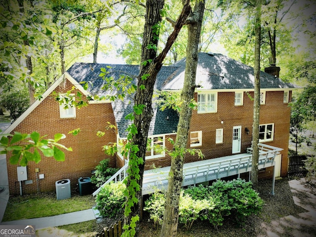 back of property with a deck and central AC unit