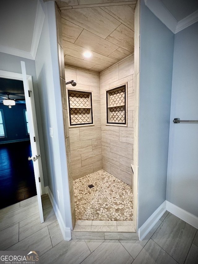 bathroom with tiled shower and crown molding