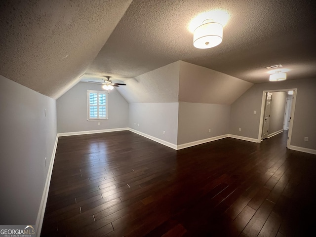 bonus room with ceiling fan, a textured ceiling, dark hardwood / wood-style flooring, and vaulted ceiling