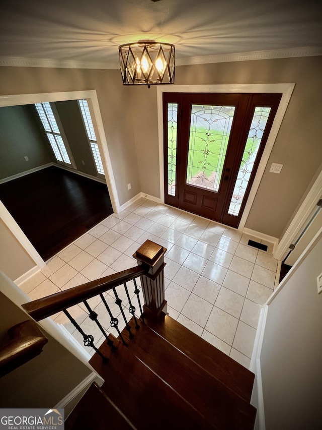 tiled foyer entrance with a chandelier