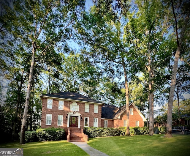 colonial-style house featuring a front lawn