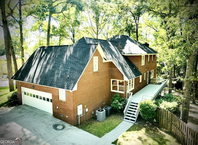 view of front of home with a garage and cooling unit