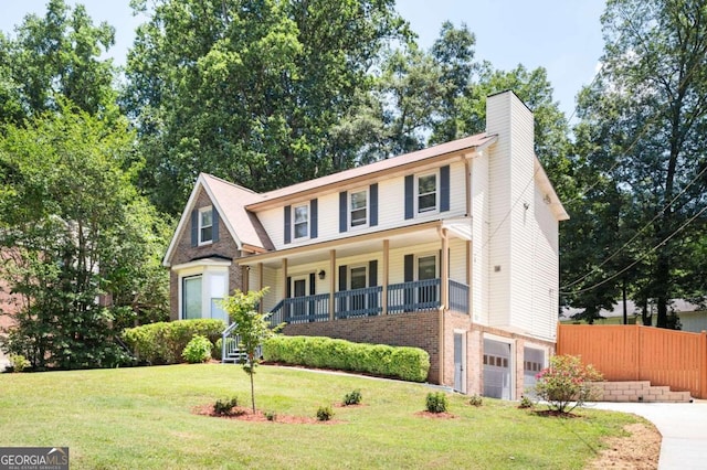 view of front of home featuring a garage, a front lawn, and a porch