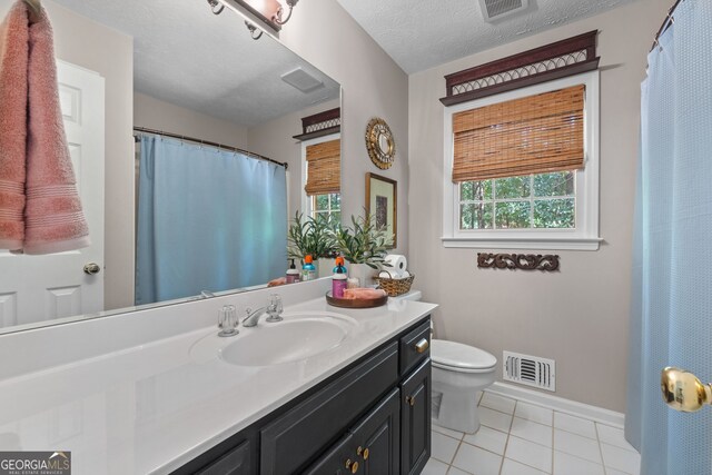 bathroom featuring vanity, tile patterned floors, a textured ceiling, and toilet