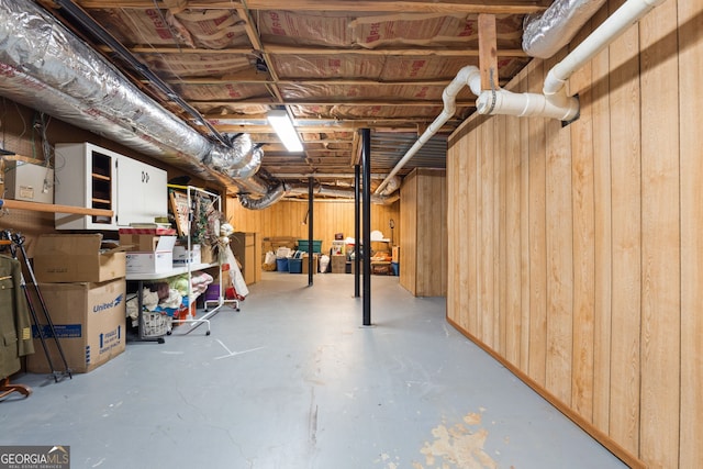 basement featuring wooden walls