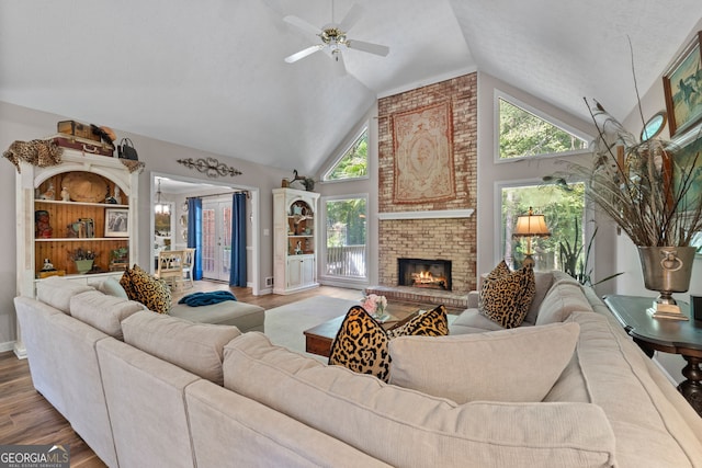 living room featuring a fireplace, ceiling fan, light wood-type flooring, and a healthy amount of sunlight