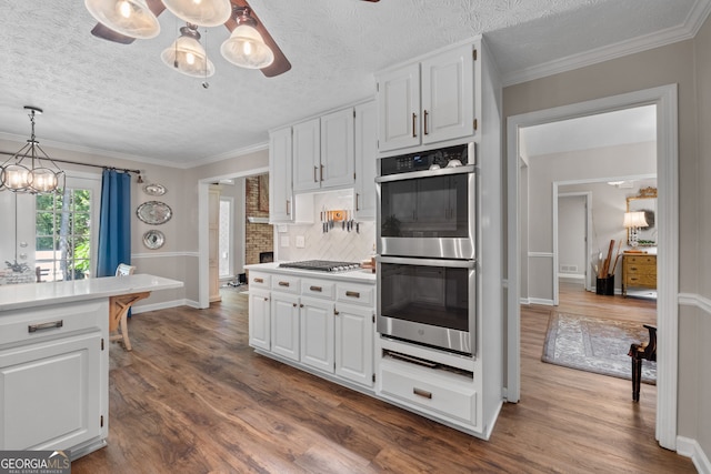 kitchen with white cabinets, stainless steel double oven, tasteful backsplash, and dark wood-type flooring