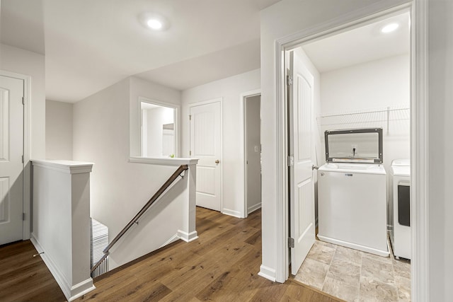 laundry room with separate washer and dryer and light hardwood / wood-style flooring