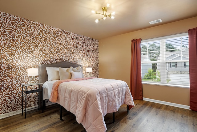 bedroom with a chandelier, dark hardwood / wood-style floors, and multiple windows