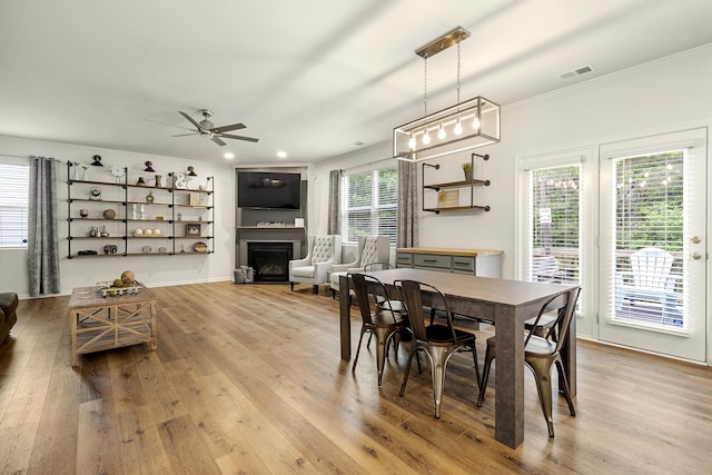 dining space featuring light hardwood / wood-style floors, ceiling fan, and ornamental molding