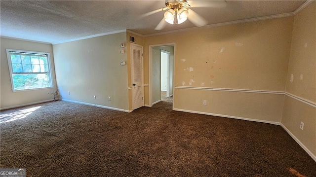 empty room featuring dark colored carpet, ceiling fan, ornamental molding, and a textured ceiling