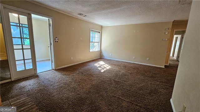 unfurnished room with a textured ceiling, dark carpet, and crown molding