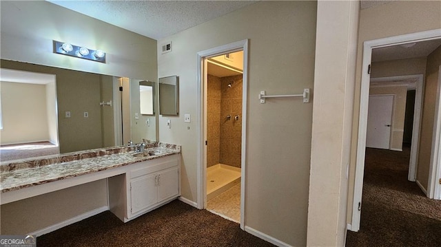 bathroom with vanity, a textured ceiling, and walk in shower