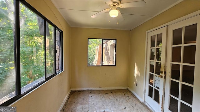 unfurnished sunroom featuring ceiling fan and french doors