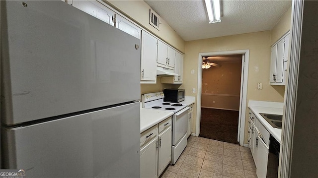 kitchen featuring appliances with stainless steel finishes, a textured ceiling, sink, white cabinets, and light tile patterned flooring