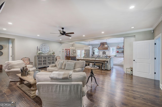 living room with crown molding, ceiling fan, and dark wood-type flooring