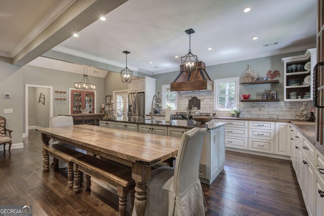 dining area with crown molding, dark wood-type flooring, and sink