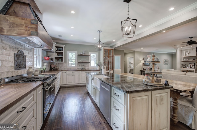 kitchen with pendant lighting, a large island with sink, dark stone counters, dark hardwood / wood-style flooring, and stainless steel appliances