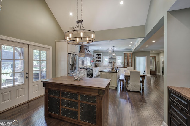 kitchen with dark hardwood / wood-style flooring, stainless steel appliances, a kitchen island, and hanging light fixtures