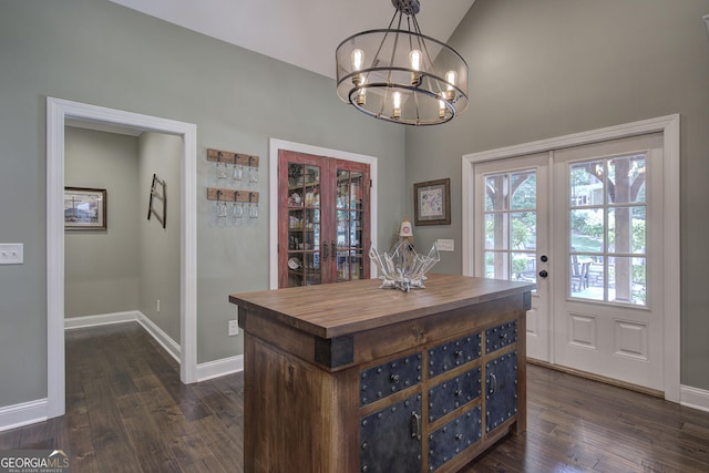 dining room featuring french doors, vaulted ceiling, dark hardwood / wood-style floors, and an inviting chandelier