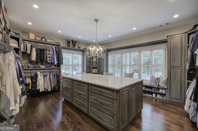 walk in closet featuring dark hardwood / wood-style floors and a notable chandelier