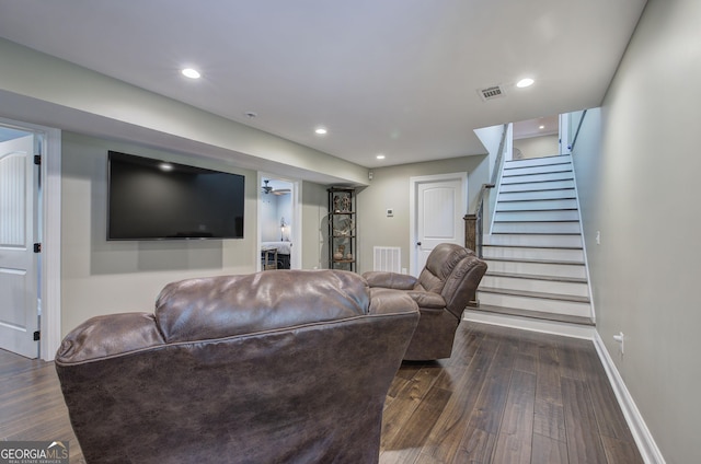 living room with ceiling fan and dark wood-type flooring