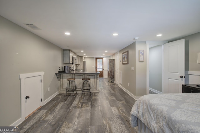 bedroom featuring stainless steel fridge and dark wood-type flooring