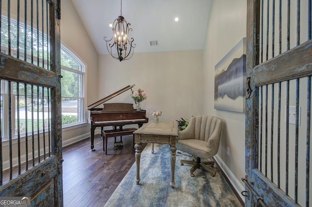 living area with a wealth of natural light, high vaulted ceiling, dark hardwood / wood-style floors, and an inviting chandelier