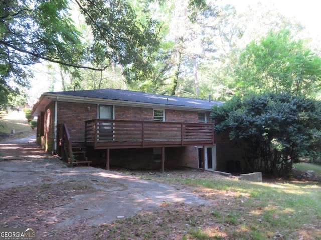 rear view of house featuring a wooden deck