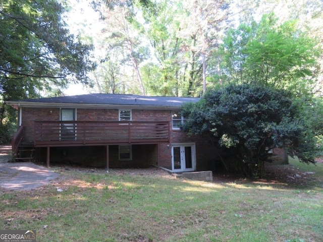 rear view of house featuring a lawn, french doors, and a deck