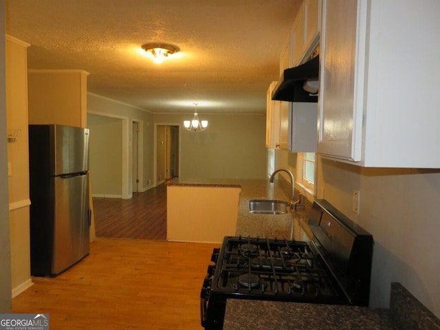 kitchen featuring stainless steel fridge, light wood-type flooring, black range with gas cooktop, sink, and a chandelier