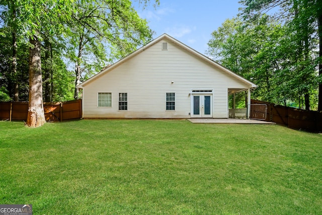 back of house featuring a lawn, french doors, and a patio area