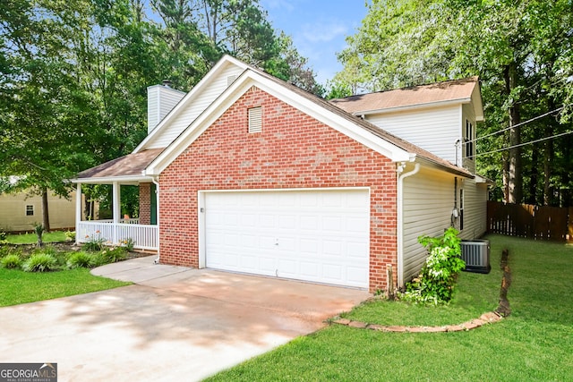 exterior space featuring a garage, central AC, a front yard, and covered porch