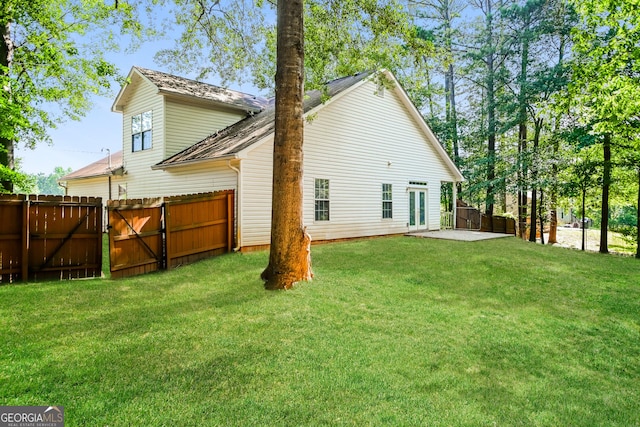 rear view of property with a yard and a patio area