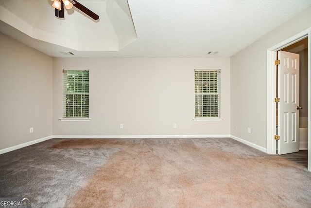 carpeted empty room featuring ceiling fan and a tray ceiling