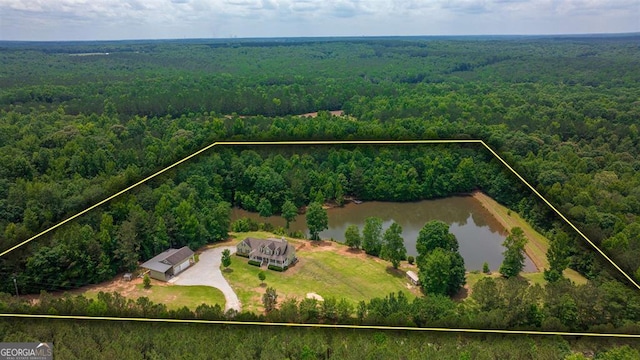 birds eye view of property featuring a water view and a wooded view