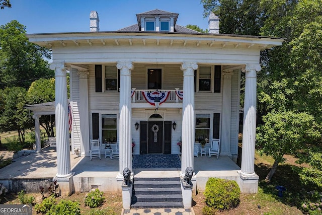 greek revival house featuring a balcony and a porch