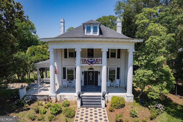 neoclassical / greek revival house with a balcony and covered porch