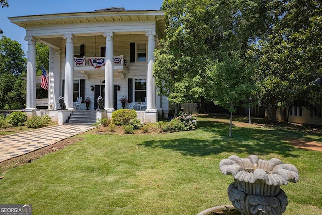 neoclassical / greek revival house featuring a front yard and a balcony