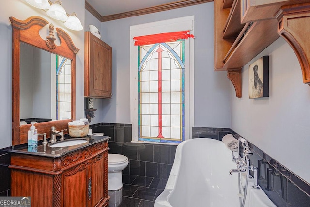 bathroom featuring ornamental molding, a bath, tile walls, toilet, and plenty of natural light