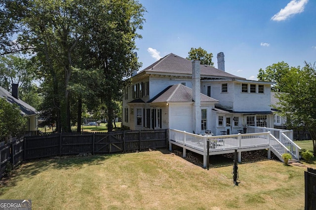 back of property featuring a yard and a deck