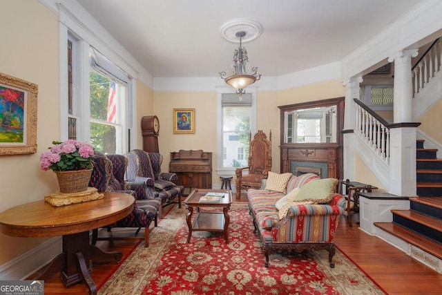 living area featuring decorative columns and wood-type flooring