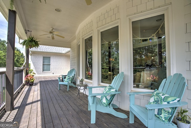 wooden deck featuring covered porch and ceiling fan