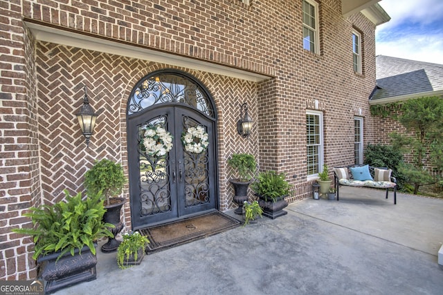 view of exterior entry featuring a patio area and french doors