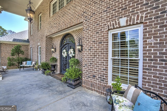 view of exterior entry with a patio area