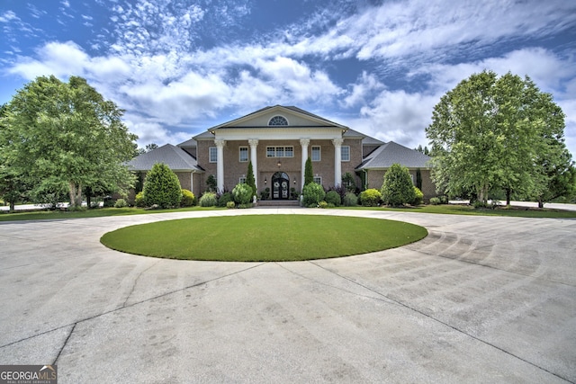 greek revival inspired property featuring a front yard