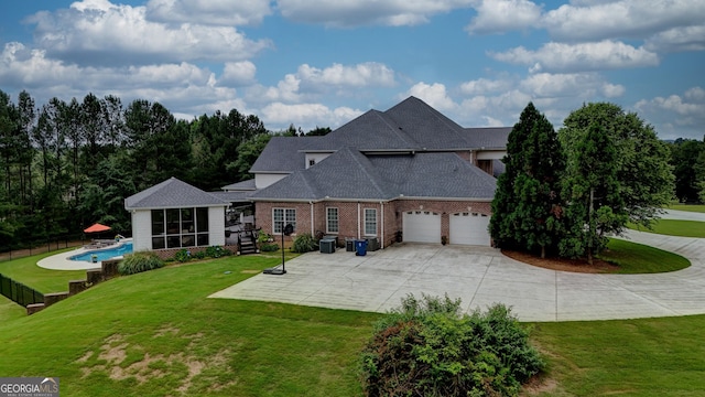 view of front facade featuring a garage, a front lawn, and a sunroom